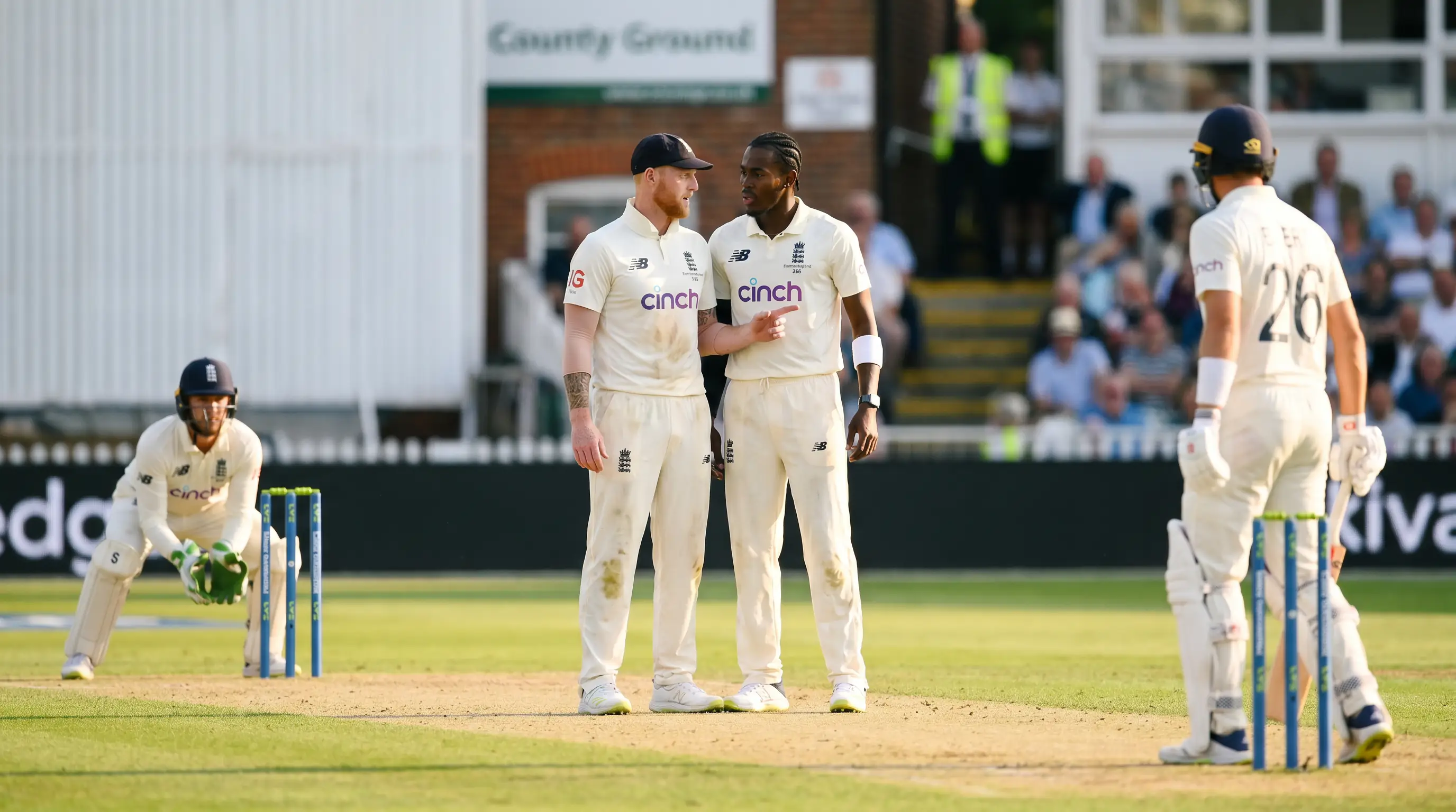 Captain talks tactics with a bowler at the top of his run-up between overs