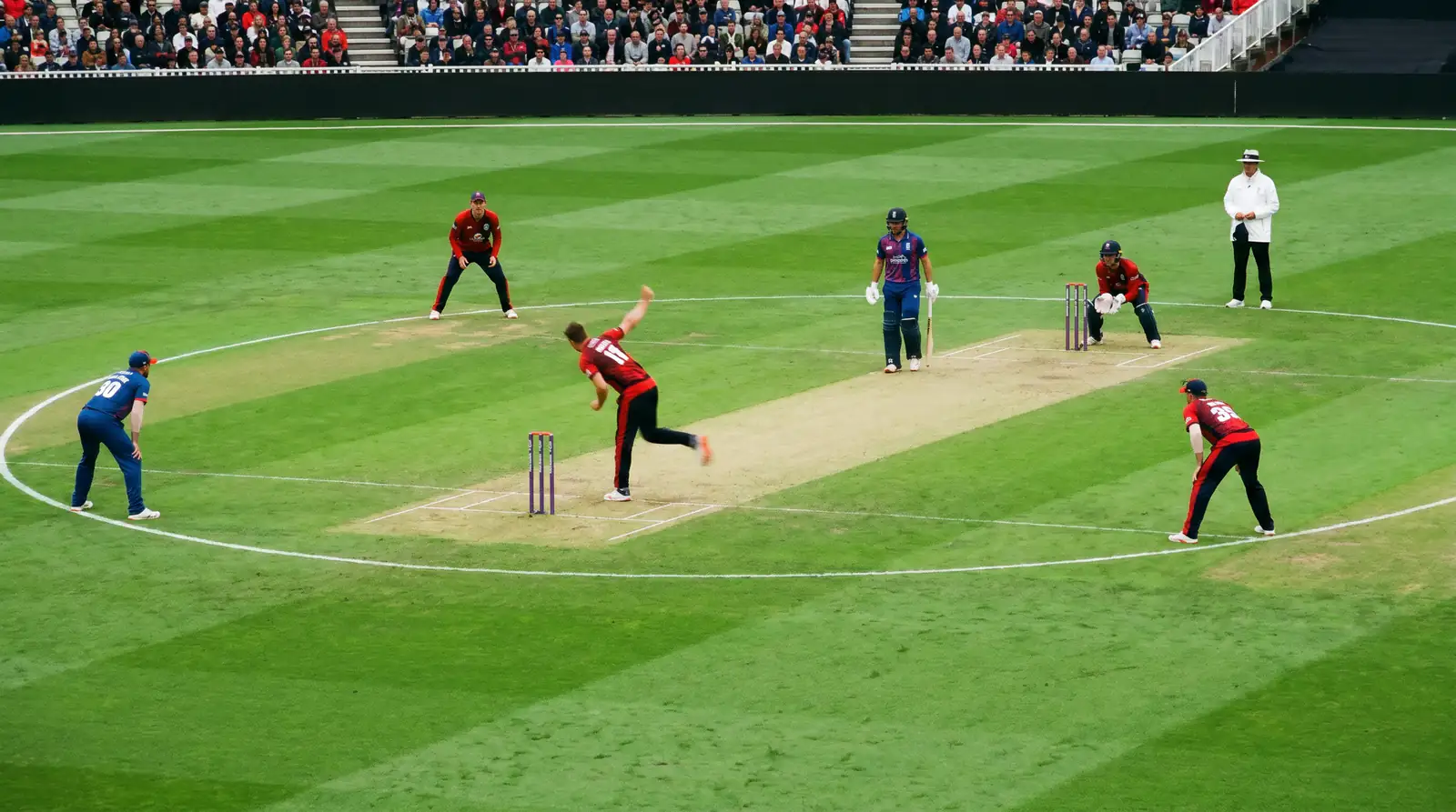 Fielders standing inside the powerplay circle while a fast bowler delivers during a T20 cricket innings